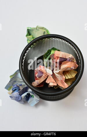 Konzept Geld zu verschwenden. Weggeworfenes Geld. Geld im Papierkorb. Geld zu verlieren. verschwenderische Ausgaben. verschwenderische Ausgaben. Stockfoto