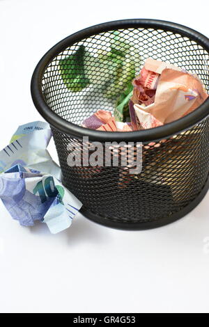 Konzept Geld zu verschwenden. Weggeworfenes Geld. Geld im Papierkorb. Geld zu verlieren. verschwenderische Ausgaben. verschwenderische Ausgaben. Stockfoto