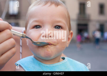 Mutter füttert ihr Baby Boy mit Obst Brei im freien Stockfoto