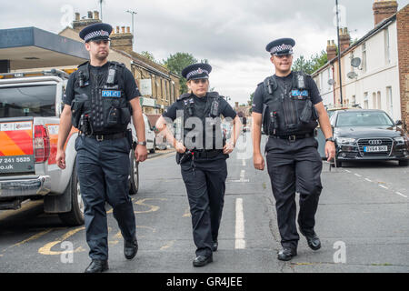 Polizeistreife Polizistin und zwei Polizisten auf Straße Stockfoto