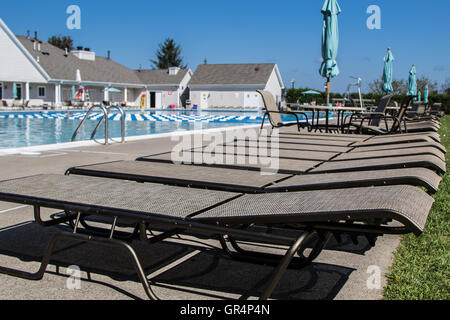 Eine Reihe von Sonnenliegen mit einem Swimmingpool. Stockfoto