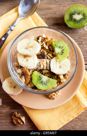 Hausgemachtem Müsli mit Obst (Banane, Kiwi) und Muttern für gesundes Frühstück Stockfoto