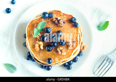 Hausgemachte Pfannkuchen mit Heidelbeeren, Honig und Walnüssen zum Frühstück (Draufsicht) Stockfoto