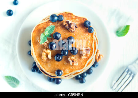 Hausgemachte Pfannkuchen mit Heidelbeeren, Honig und Walnüssen zum Frühstück (Draufsicht) Stockfoto
