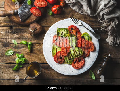 Heairloom-Tomaten-Salat mit Basilikum, Olivenöl und Balsamico-Essig Stockfoto