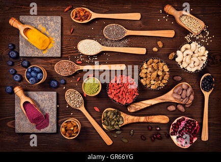 Super-Lebensmittel in Löffel und Schalen auf einem hölzernen Hintergrund Stockfoto