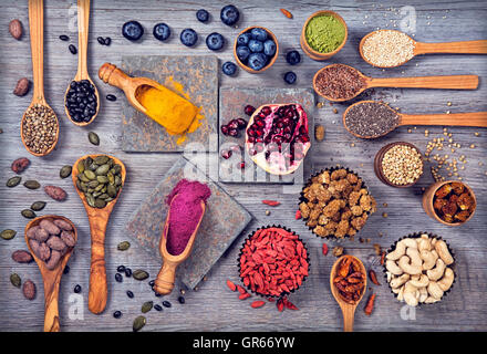 Super-Lebensmittel in Löffel und Schalen auf einem hölzernen Hintergrund Stockfoto