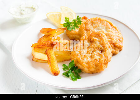 Hausgemachte Fischfrikadellen mit Pommes Frites auf weißen Teller hautnah Stockfoto