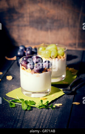 Magerer Joghurt mit Cornflakes und Trauben frischer Minze Stockfoto