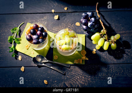 Magerer Joghurt mit Cornflakes und Trauben frischer Minze Stockfoto