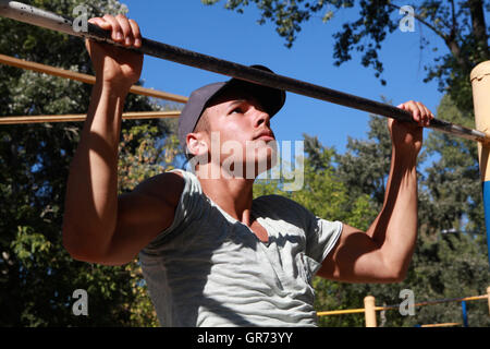 Sie können Treffen Amateure und internationale Spitzensportler in Kiew Hydropark riverside Erholung sind. Bild: Gymnast zieht auf der horizontalen Leiste Stockfoto