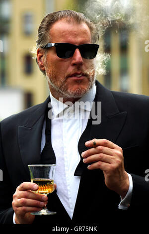 Mann mit dem Rauchen mit einem Glas Wein und Zigarette Stockfoto