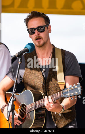 Broadstairs folk Woche. Junger Mann folk Sänger Gitarrist, trug eine dunkle Sonnenbrille, die im Musikpavillon. Nahaufnahme von Sänger und Gitarre. Stockfoto