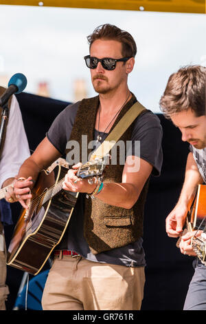 Broadstairs folk Woche. Junger Mann folk Sänger Gitarrist, trug eine dunkle Sonnenbrille, die im Musikpavillon. Nahaufnahme von Sänger und Gitarre. Stockfoto