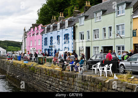 Besucher vor den bunten Häusern entlang der Hafen Waterfront, Portree, Isle Of Skye, Schottland, Vereinigtes Königreich Stockfoto