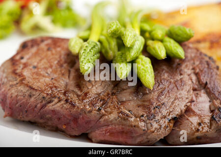 Wilder Spargel auf ein Steak Stockfoto