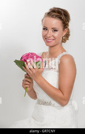 3/4 Schuss eines ziemlich junge Braut im weißen Hochzeitskleid Stockfoto