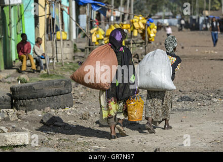 Zwei Frauen mit schweren Taschen auf dem Weg zu den lokalen Markt In Goba, Bale Region, Bono, Äthiopien Stockfoto