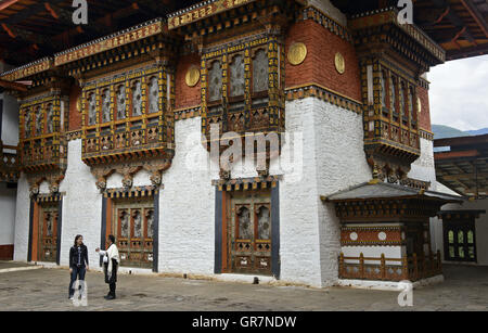 Stadtführer mit Besucher im Hof des Klosters und Festung Punakha Dzong, Punakah, Bhutan Stockfoto