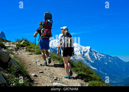 Ehepaar mit Kleinkind In einer Kindertrage Rucksack auf einem Wandern Tour, Mont Blanc Massiv hinter, Chamonix, Frankreich Stockfoto