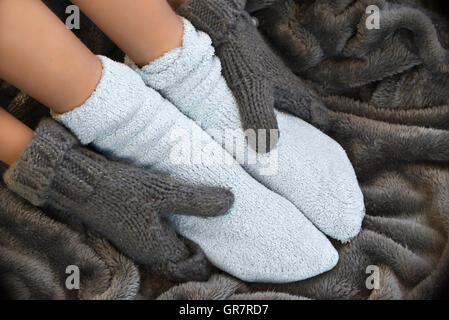 Füße in komfortablen und warmen Wollsocken auf einer Decke Stockfoto