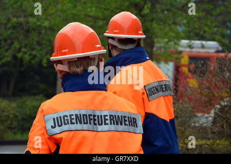 Zwei junge Feuerwehrmann In Uniform stehen auf der Straße Stockfoto