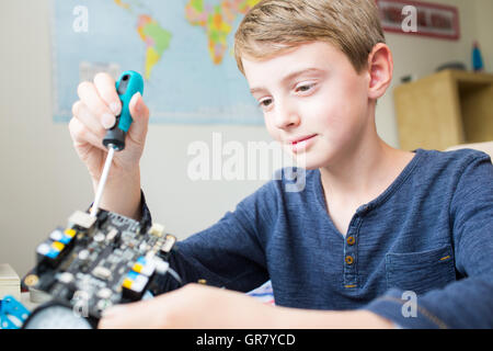 Junge Montage Roboter Kit im Schlafzimmer Stockfoto