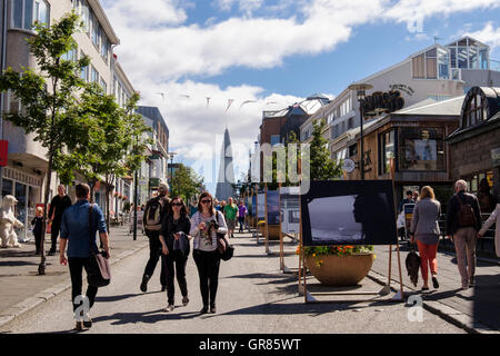 Viel befahrenen Straße Szene mit Gemälden auf der Anzeige und der Lutherischen Kirche Hallgrímskirkja auf einem Hügel. Skolavordustigur Reykjavik Island Stockfoto