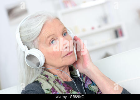 Alte Dame mit Kopfhörer auf Stockfoto