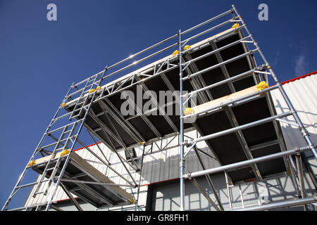 Ein großes Gerüst Arbeitsbühne mit einer Aluminium-Tower-System erstellt. Steht neben einem Lagergebäude Stockfoto