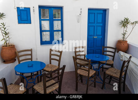 Tische und Stühle vor einem Haus in der traditionellen Dorf Nikia in Nisyros Insel, Griechenland Stockfoto