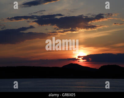 Sonnenuntergang und Orange bewölktem Himmel über die Berge in Kroatien Stockfoto