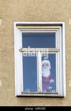 Santa Claus Figur hinter einer Fensterscheibe Stockfoto