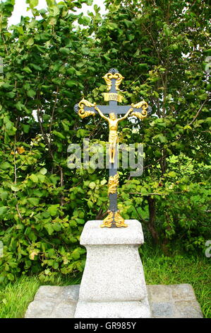 Metal Cross auf eine leichte Steinsockel In Nesselwang im Allgäu Stockfoto