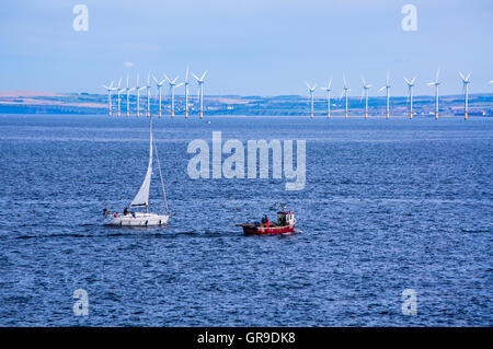 Ein Fischerboot und Yacht von Teesside Windpark gesehen von der Landzunge, Hartlepool, County Durham, England Stockfoto