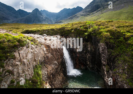 Wasserfall bei der Fee-Pools in Glen spröde mit Cuillin Hills hinter, Isle Of Skye, Schottland, Vereinigtes Königreich Stockfoto