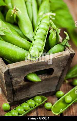 Frische reife grüne Erbsen in Holzkiste Stockfoto