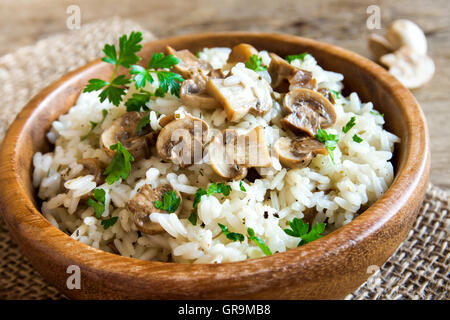 Pilz-Risotto mit Petersilie in Holzschale hautnah Stockfoto