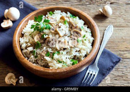 Pilz-Risotto mit Petersilie in Holzschale hautnah Stockfoto