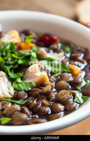 Linsensuppe mit Huhn und Gemüse in weiße Schüssel hautnah Stockfoto
