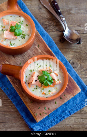 Lachssuppe mit Nudeln und Gemüse in Keramikschalen hautnah Stockfoto