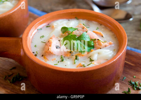 Lachssuppe mit Nudeln und Gemüse in Keramikschalen hautnah Stockfoto