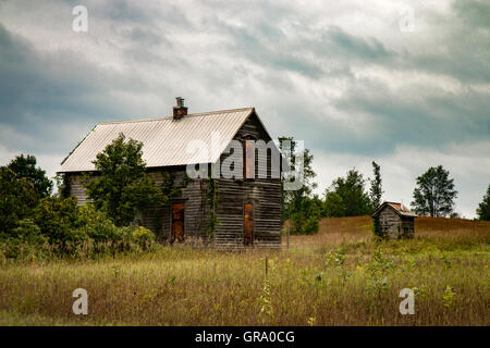 Alte verlassene Holzhaus mit Fenstern mit Brettern vernagelt. Stockfoto