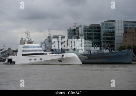 Ein 390ft Motoryacht Zugehörigkeit zu russischen Tycoon Andrey Melnichenko neben HMS Belfast (rechts) auf der Themse in London. Stockfoto