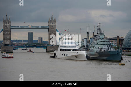 Ein 390ft Motoryacht Zugehörigkeit zu russischen Tycoon Andrey Melnichenko neben HMS Belfast (rechts) auf der Themse in London. Stockfoto
