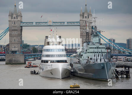 Ein 390ft Motoryacht Zugehörigkeit zu russischen Tycoon Andrey Melnichenko neben HMS Belfast (rechts) auf der Themse in London. Stockfoto