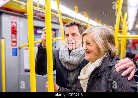 Älteres Paar steht in einer überfüllten u-Bahn Stockfoto