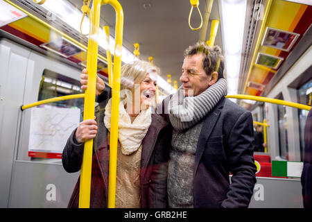 Älteres Paar steht in einer überfüllten u-Bahn Stockfoto