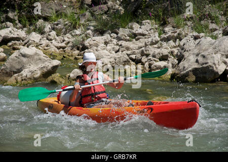 Tourismus, Wassersport. Junge lächelnde Frau Kanu die felsigen turbulenten schnellen fließenden Gewässern des Flusses Drôme. In der Nähe von Saillans, La Drôme, Frankreich. Stockfoto