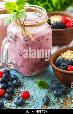 Gut sein und Gewicht-Verlust-Konzept, Beeren-Smoothie und Haferflocken auf Holztisch mit Zutaten Stockfoto